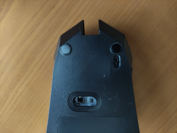 无线黑色游戏鼠标放在桌上，后视图图片下载