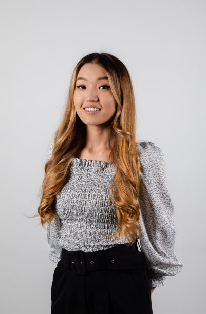 微笑的金发亚洲女孩长卷发在白色的背景图片下载