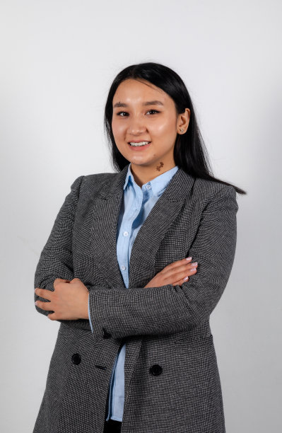 一名身着正装、面带微笑的年轻亚洲女子双手交叉的肖像图片下载