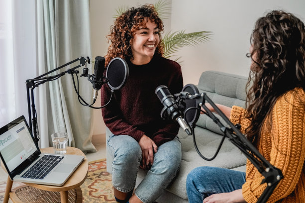 女主持人录制电台播客访谈客人在家里办公室-关注拉丁女人的脸图片下载