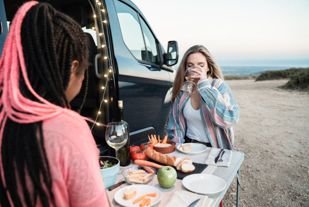 多种族快乐的朋友在山中的露营车前吃素食-专注于对的女孩图片下载