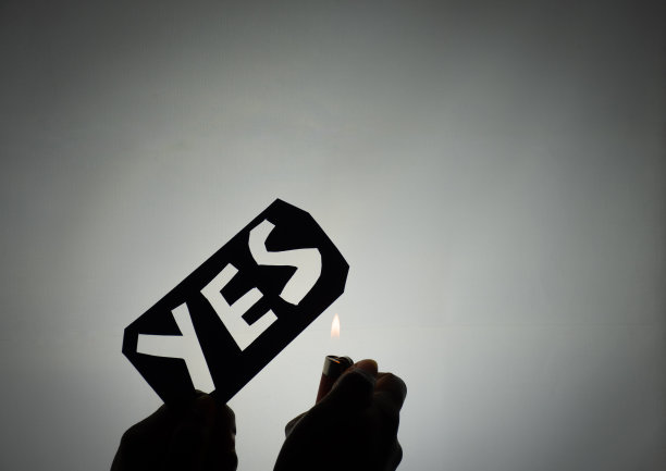 一个人把一张写着“是”的纸藏起来的剪影，旁边放着打火机图片下载