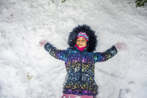 俯视图肖像的女孩做雪天使图片下载