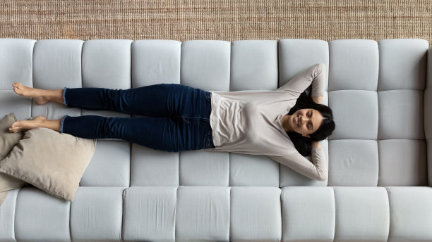 俯视：亚洲女性在舒适沙发上放松微笑图片下载