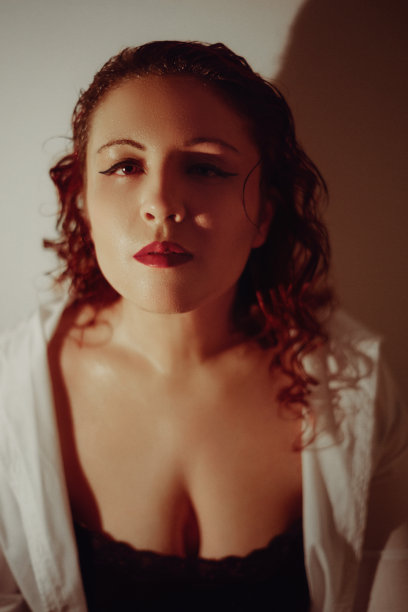 年轻女子的肖像，涂着眼线和红色唇膏，看着相机图片下载