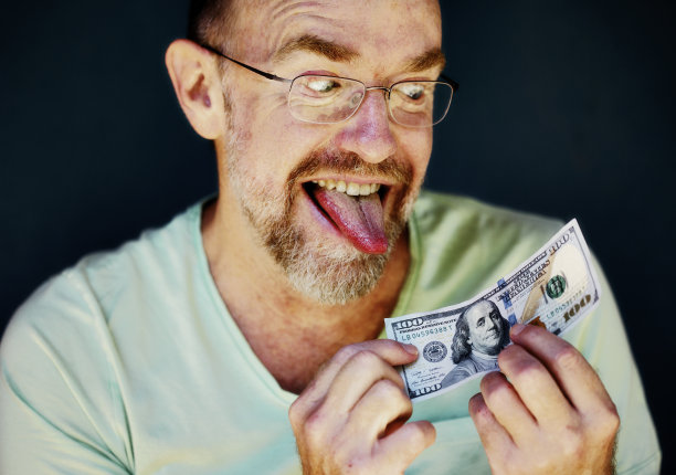 男子手持100美元钞票图片下载