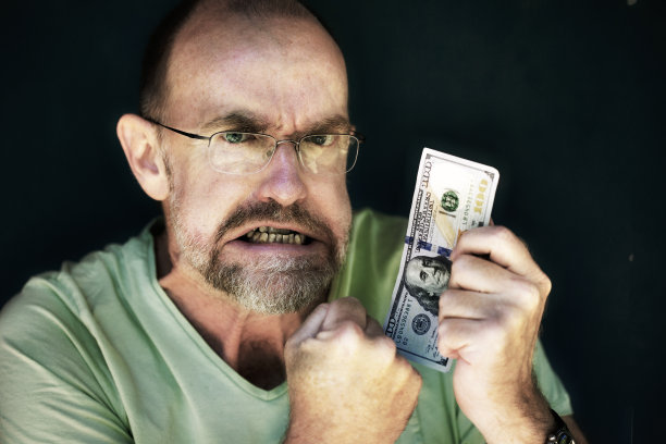 男子手持100美元钞票图片下载