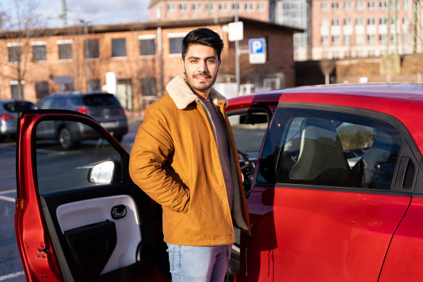 拉丁或阿拉伯人站在车旁，在城市的停车位上车门打开图片下载