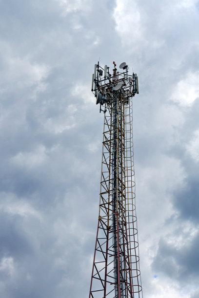 多云天空背景下的金属电信塔图片下载