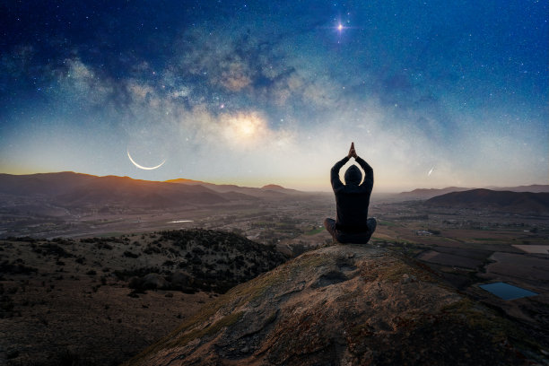 夜晚在银河和月亮下，人们在山上户外做瑜伽或冥想图片下载