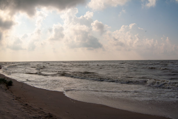 海景前有雨，天空有云。海浪在沙滩上翻滚。海滨背景为一个帖子，屏幕保护程序，墙纸，明信片，海报，横幅，封面，网站。高质量的照片图片下载