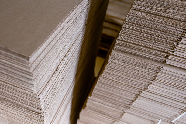 折叠纸箱。穿孔的瓦楞纸板堆叠在托盘上。工业生产成品的包装。图片下载