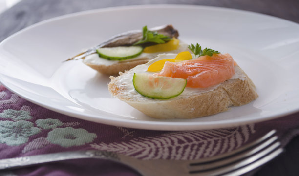 三明治，三文鱼和小鲱鱼放在盘子里的三明治。宏观背景。高质量的照片。宴会。图片下载