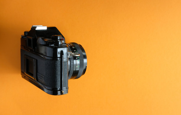 经典模拟单反相机，来自橙色背景的电影摄影时代图片下载