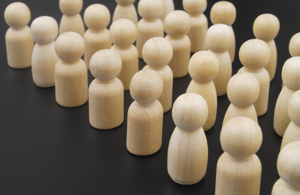 许多木制的人物在黑色的背景下彼此站在一起图片下载