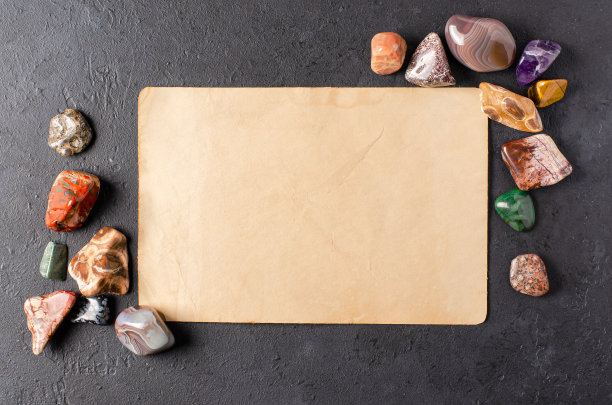 矿石和一张旧纸。黑色的具体背景。在占星术和替代医学中使用矿物质的概念。副本的空间。图片下载