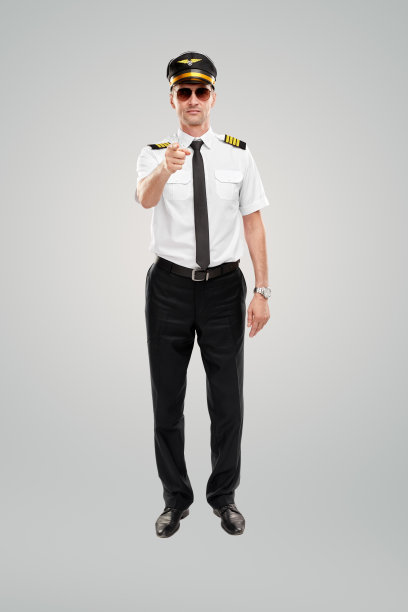自信的年轻男性飞行员指着灰色背景下的摄像机图片下载