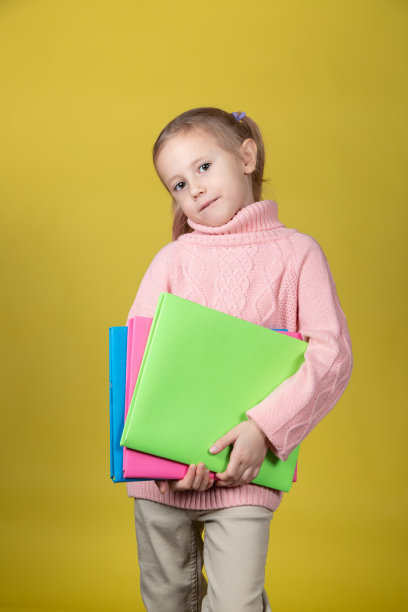 在黄色背景上有吸引力的小学女孩的肖像图片下载