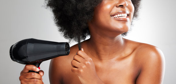 一个不认识的女人在灰白的背景下擦干头发图片下载