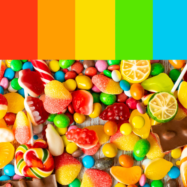 彩虹色的糖果。五颜六色的水花溅在桌子上，调色板上的颜色图片下载