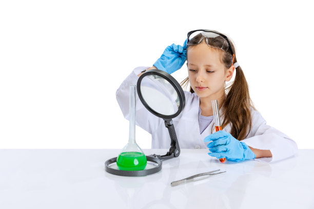 一个严肃的小女孩，穿着白色大褂的孩子，像个化学家，科学家在实验室里用各种颜色的化学液体做实验图片下载