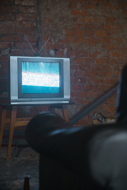 废弃的仓库里有电视，电视静电靠着砖墙图片下载