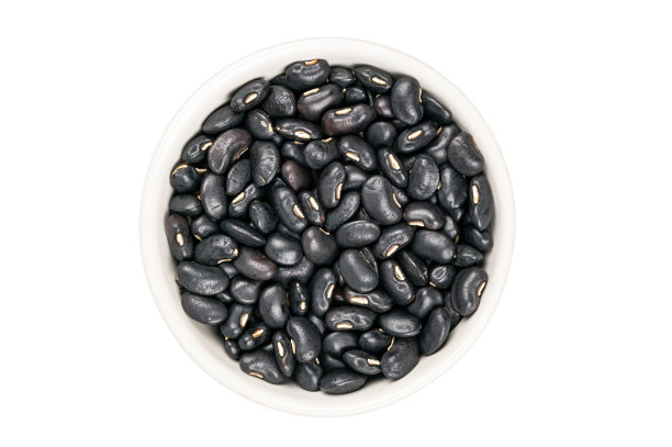 平躺(俯视图)黑豆在白色陶瓷杯。图片下载