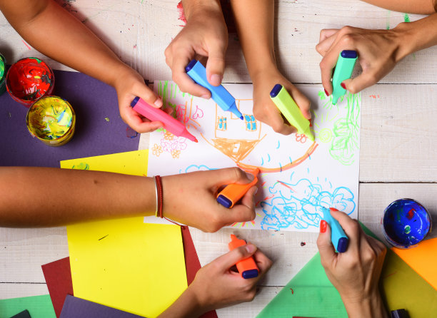 手握彩色马克笔，画孩子插图，俯视图。图片下载