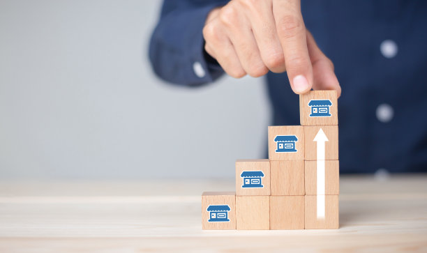 加盟商，商人手选木制博客，用加盟营销图标开店。特许经营业务的概念。图片下载