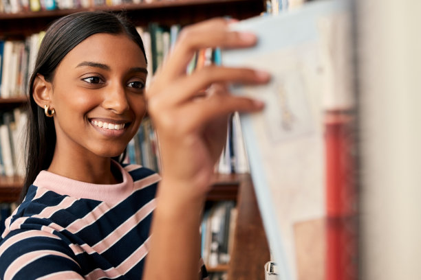 这是一个年轻的女学生在大学图书馆做研究的照片图片下载