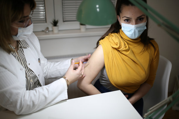 戴着口罩的年轻女子在医院或健康中心接种抗病毒疫苗的照片图片下载