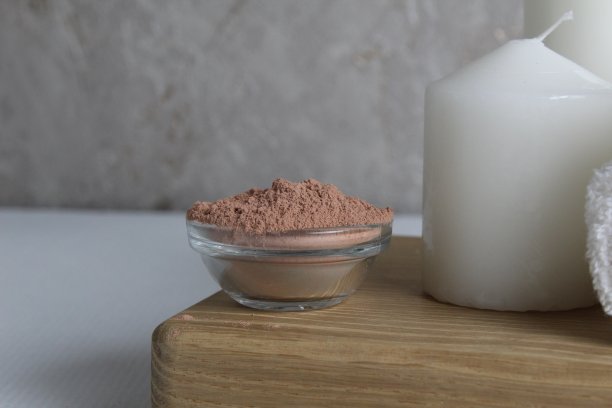 水疗，休息，放松。油粘土包裹蜡烛面具白色毛巾按摩在一个木制托盘上的白色灰色混凝土背景从侧面的特写视图。家庭的身体护理图片下载