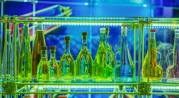绿色瓶子在各种形状的特写站在陈列柜的架子上。闪亮的充满活力的背景图片下载