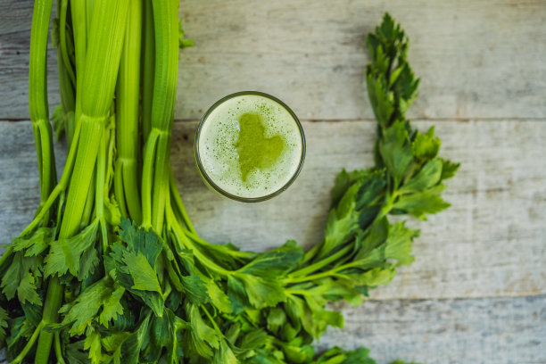 芹菜汁，健康饮料，一串芹菜放在木制的背景上图片下载