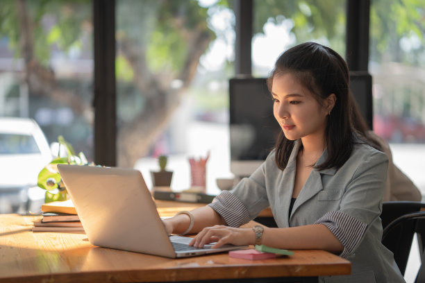 吸引人的亚洲商人的肖像与笔记本电脑在她的办公室工作图片下载