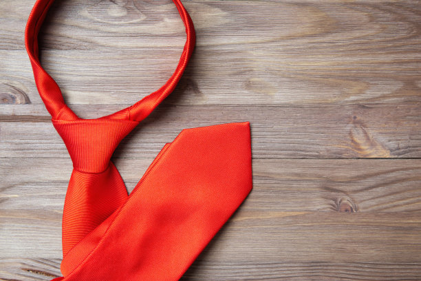 一张木桌上坚实的红色领带的特写图片下载