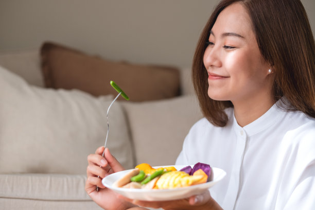 一个年轻女人吃蔬菜的肖像形象，素食，清洁的食物，节食的概念图片下载