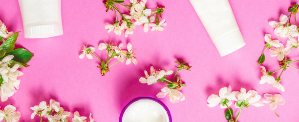 装饰化妆品产品和鲜花在粉红色的背景。春季化妆品销售横幅。美容院宣传横幅。图片下载