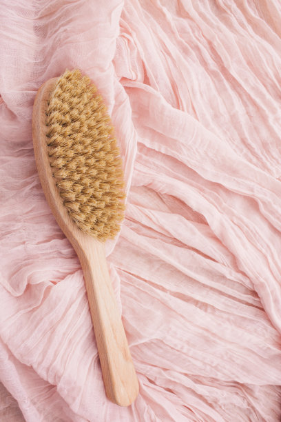 木刷在粉红色的背景干按摩。侘寂的美学。天然材料。图片下载