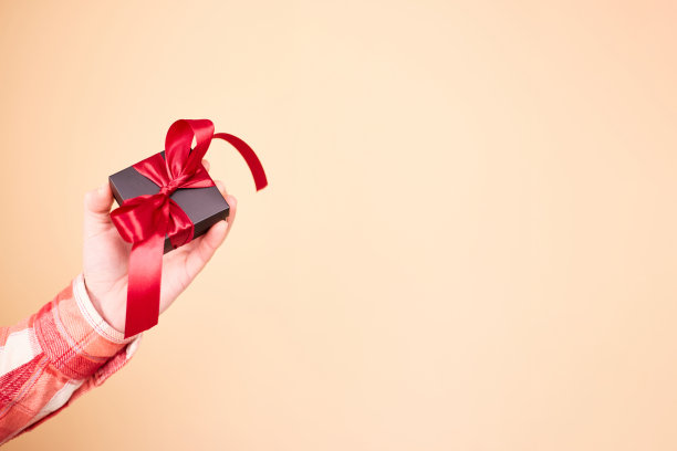 男性手中礼物盒的特写照片。拿着礼品盒的男人。情人节。生日或节日的概念。本空间图片下载