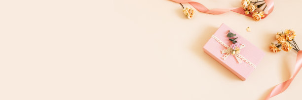美丽的粉红色礼盒与干玫瑰花和缎带在柔和的背景。节日、生日、婚礼、母亲节、情人节、妇女节的礼物。副本的空间。俯视图，平躺。横幅图片下载
