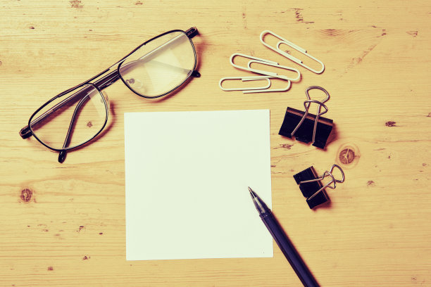 办公室的办公桌场景与笔，纸，眼镜，回形针和牛夹图片下载