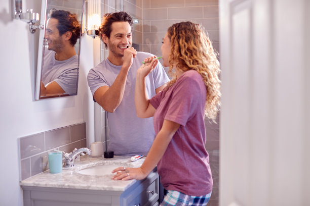 穿着睡衣的情侣在浴室里一起刷牙图片下载