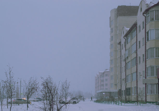 雪天傍晚的街道和居民楼的照片图片下载