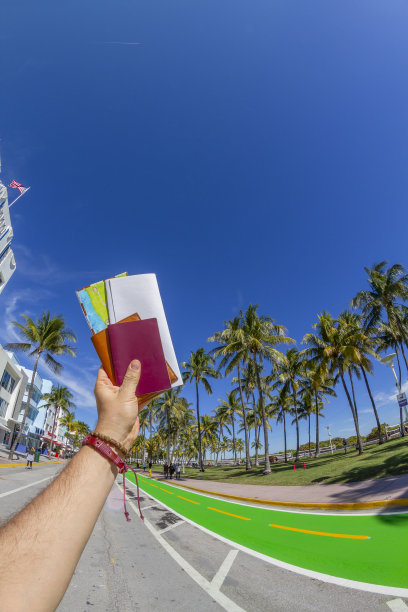 在迈阿密手持护照和地图的年轻游客视角图片下载