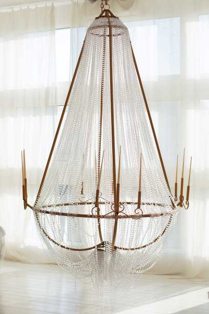 巴洛克风格的大水晶吊灯与蜡烛。美丽的水晶吊灯与许多玻璃晶体钻石闪亮。软的焦点。客厅里别致的大型电吊灯。图片下载