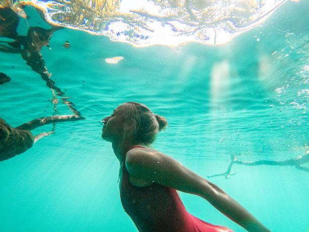 一个女人在热带天然井里潜水，水下拍摄图片下载