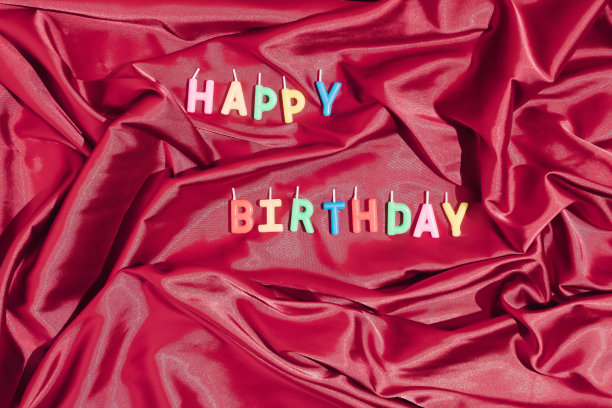 优雅的贺卡。生日快乐，恭喜海报，红绸上的生日蜡烛。图片下载