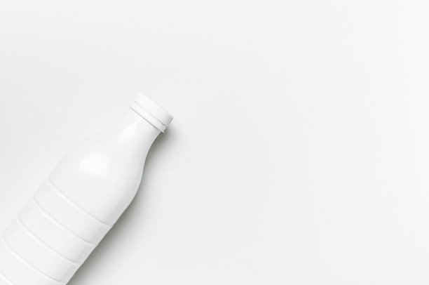 白色塑料瓶容器的乳制品浅灰色背景俯视图平躺。塑料开菲尔酸奶奶瓶。包装模板模型。设计的布局图片下载
