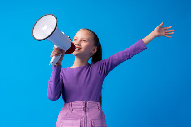 小女孩在蓝色背景下使用扩音器图片下载
